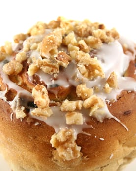 Delicious sweet sticky iced bun with walnuts and coconut.
