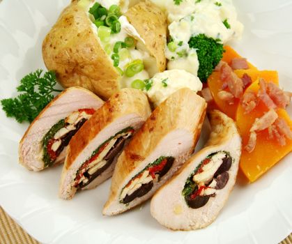 Chicken stuffed with a Mediterranean filling made of spinach, fetta, peppers and olives with vegetables.