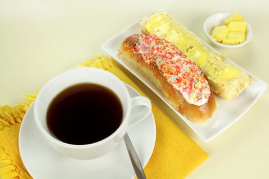 Sweet sticky bun with coffee and butter with copy space.