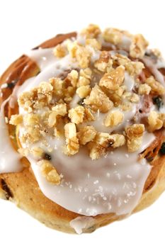 Delicious sweet iced bun with walnuts and coconut.