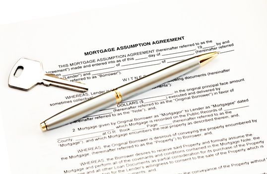 Mortgage assumption agreement with a pen for signature and a key
