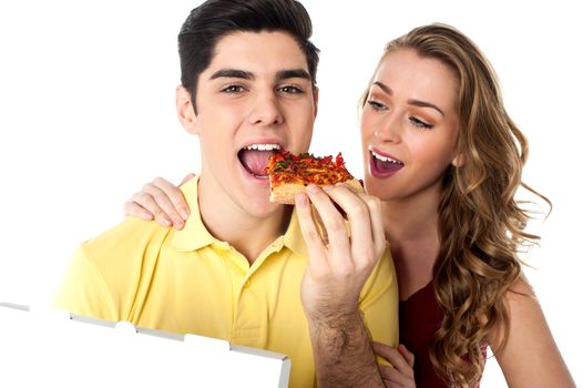 Hungry young couple relishing a slice of pizza