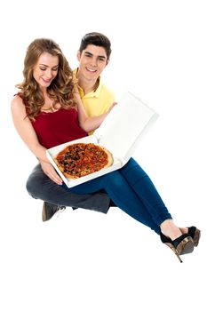 Pretty girl on boyfriend's lap holding pizza