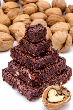One pyramid of brownies with walnuts on a white background