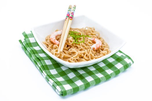 Composition of a bowl of noodles with shrimps on a green cloth