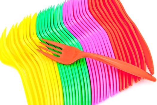 Multi colored plastic cutlery on a white background