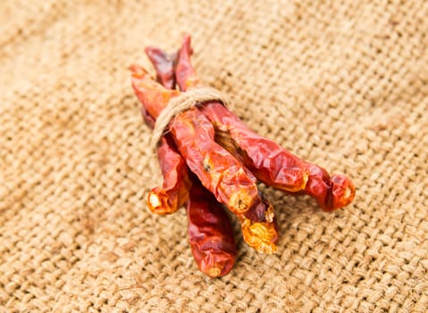 Dried chili peppers on sack background