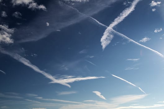 Contrails stretch across an almost cloudless summer sky