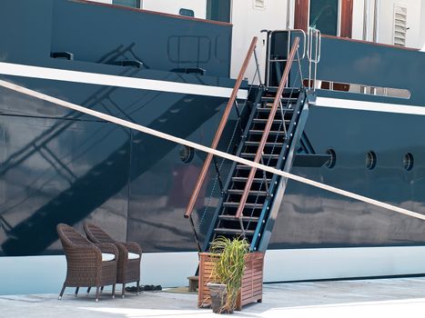 modern yacht moored in the port, gangway and reflection