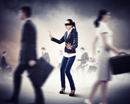 Image of businesswoman in blindfold walking among group of people