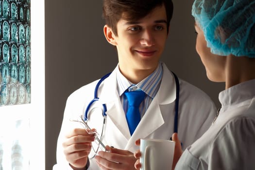 Image of two young two doctors discussing x-ray results