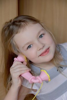 Portrait of beautiful girl with pink telephone