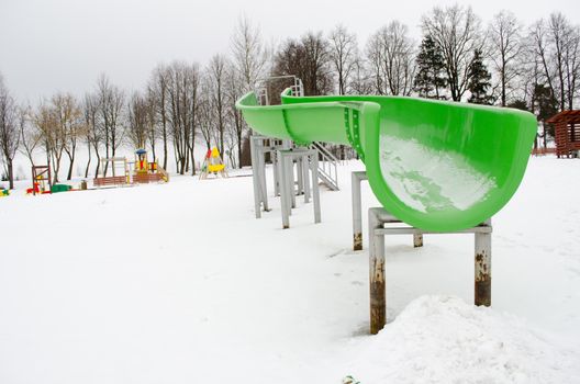 outdoor playground water park slide on frozen snowy lake in winter.