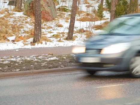 Car in high speed captured with blurry motion on wintry conditions