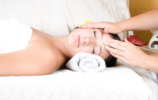 Female receiving massage therapy on face