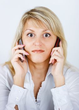 portrait of blonde girl with two mobile phones