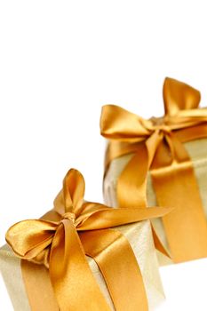 Two gift boxes in gold wrapping paper with ribbons and bows