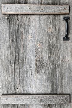 Distressed rustic barn wood door with handle as textured background