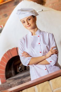 Image of young woman cook standing at kitchen