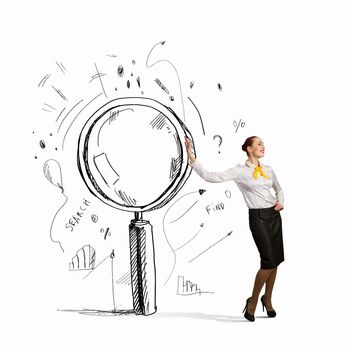 Image of young businesswoman leaning on magnifier