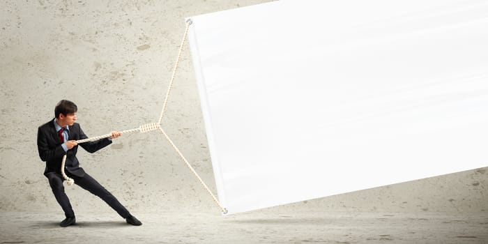 Image of businessman pulling blank banner. Place for text