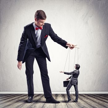 Image of young businessman puppeteer. Leadership concept