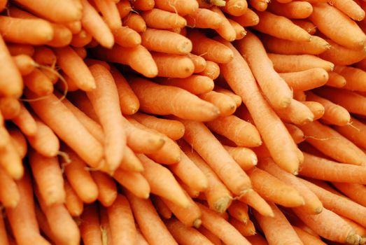 Fresh carrots piled high on a market stall