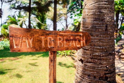 Horizontal color landscape of a wooden hand carved sign by local craftsmen displaying way to beach directions. Shot location Bombay India
