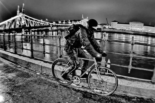 Cyclist moving next to river Danube at night