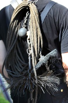 Weighted chain, rope and wire brush for cleaning chimneys being carried on the back of a chimney sweep