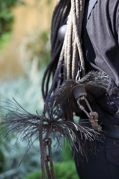 Coarse wire brushes and euipment of a chimney sweep slung over the back of a workman, close up view