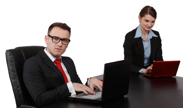 Young business colleagues working on their laptops at the office desk, isolated against a white background.The focus is selective on the man.