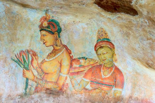 Ancient wall paintings of cloudy maidens with flower. One of the 5th century frescoes at the ancient rock fortress of Sigiriya, Sri Lanka. 