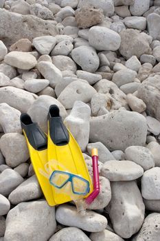 Yellow flippers with snorkel goggle and tube on the beach