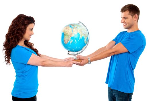 Joyous couple holding globe together and looking at each other