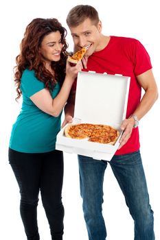 Girl sharing a pizza piece with her boyfriend. making him eat from her hands. Love couple