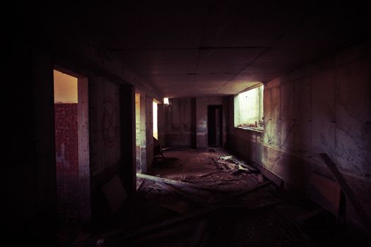 Dark gloomy interior of an abandoned dilapidated farmhouse with inside doors