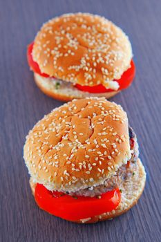 A couple of sandwiches with hamburger over wooden background