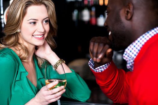 Young couple enjoying at bar, busy in romantic conversation