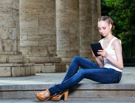 Girl in a white T-shirt with a tablet computer