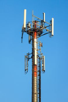 Cellular communication tower on blue sky background