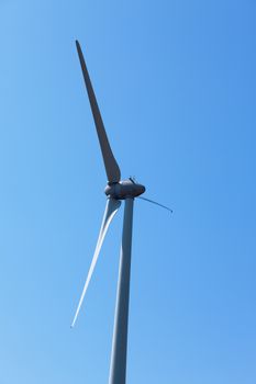Wind electric generator against blue sky background