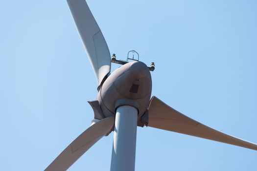 Wind electric generator against blue sky background, closeup