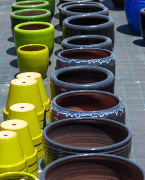 Colorful ceramic pots in market, sunny day