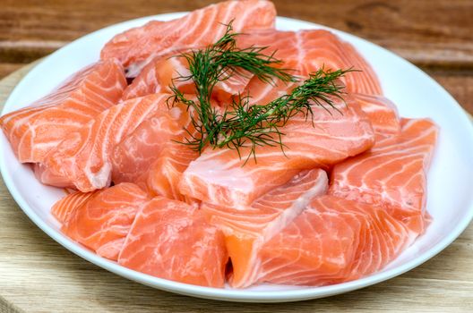 fresh salmon with dill on white plate