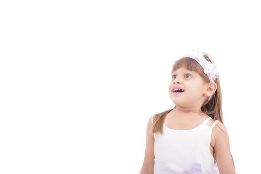 cute little girl very surprised and looking up somewhere against white background