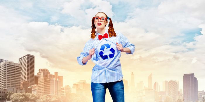 Young woman acting like super hero with recycle sign on chest