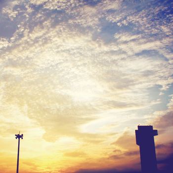 sunset in the evening sky above the building and lantern with retro filter effect