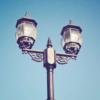 Old vintage street light against blue sky with retro filter effect