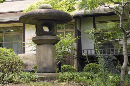 big stone lantern in Japanese zen garden by summer time